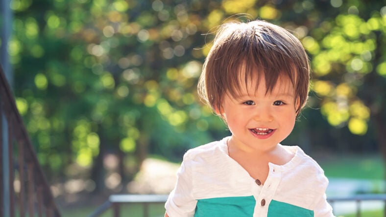 Happy toddler boy playing outside on a