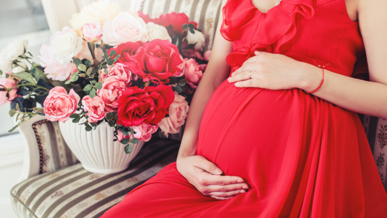 Beautiful pregnant woman touching her belly with