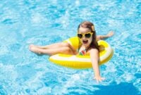 Child in swimming pool on inflatable yellow