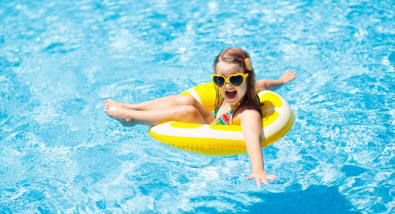 Child in swimming pool on inflatable yellow