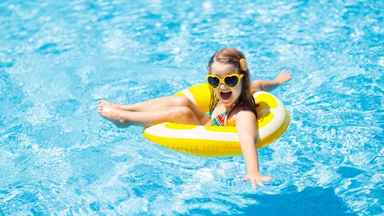 Child in swimming pool on inflatable yellow