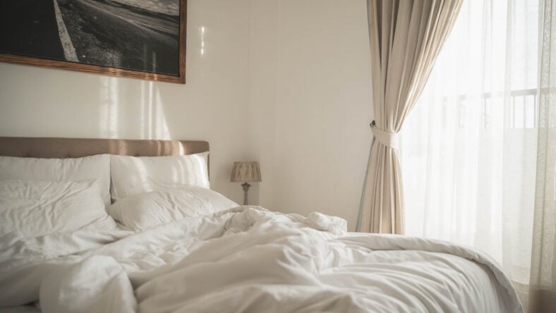 White interior of cozy bedroom with morning