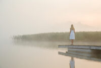 Young woman in white dress standing alone