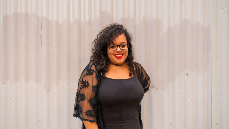 Portrait of Moroccan woman with black glasses posing in a gray sheets