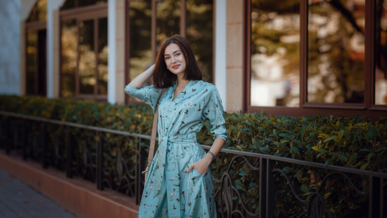 Fashion portrait of young stylish woman walking on the street, wearing cute trendy outfit, beautiful girl in a blue dress smiling enjoy her weekends.