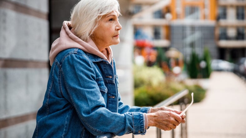 Calm mature woman is relaxing outdoors while