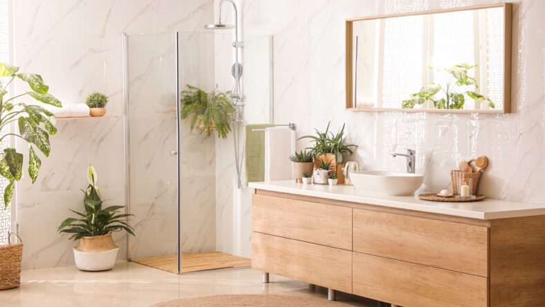 Stylish bathroom interior with countertop, shower stall and houseplants. Design idea