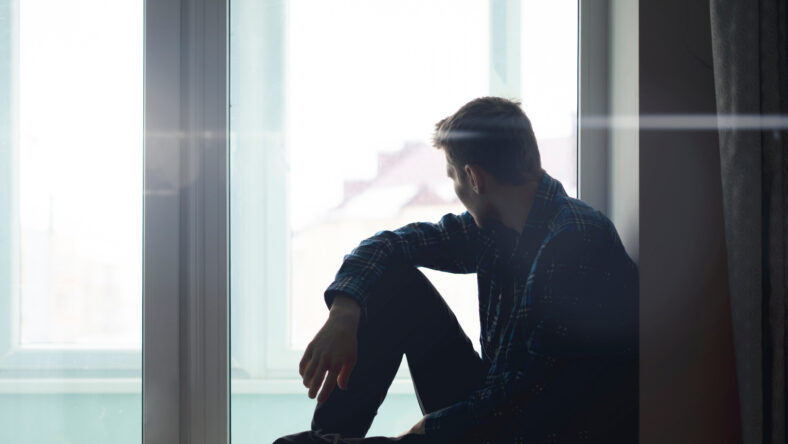 sad lonely thoughtful man silhouette sitting on