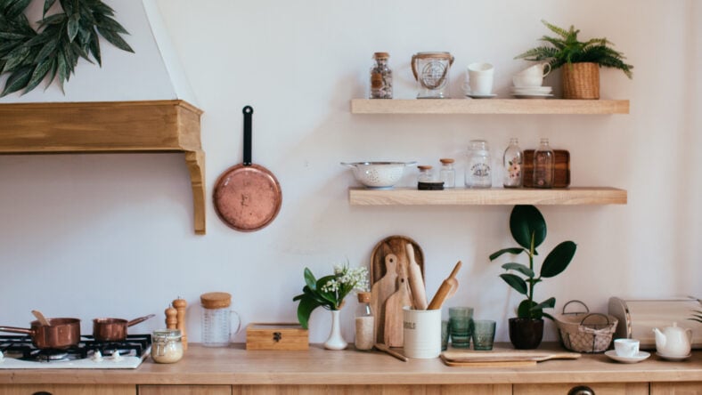 wooden rustic kitchen table. minimalistic interior, utencils on the table, jars on shelf