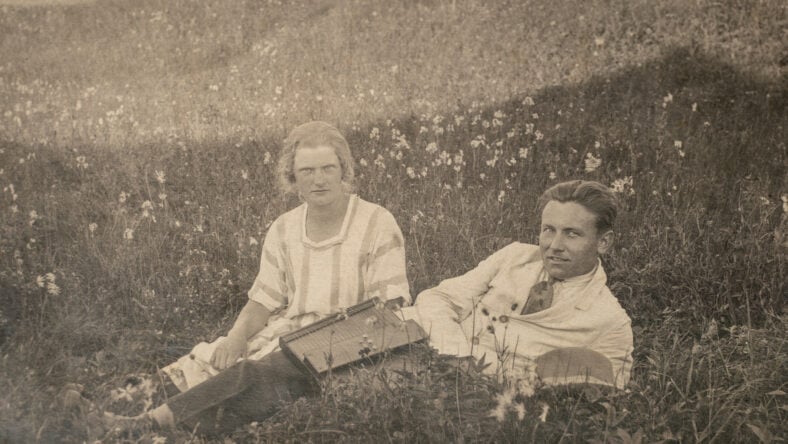 Married couple relaxing at field during picnic.