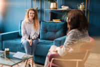 Happy red-haired woman talking to a female