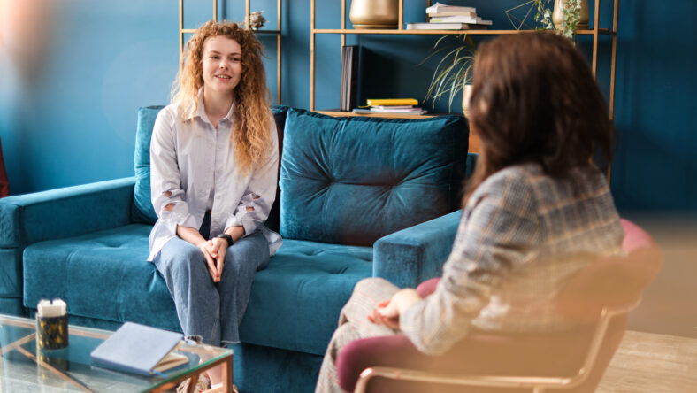 Happy red-haired woman talking to a female