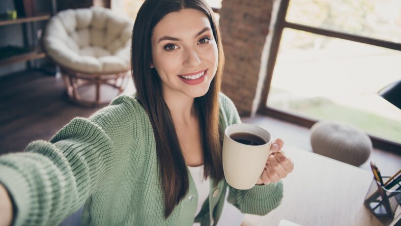 Portrait of optimistic girl doing selfie drink coffee from home wear green shirt indoors.
