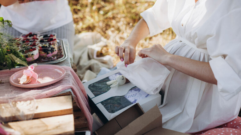 pregnant woman opens a gift. baby shower