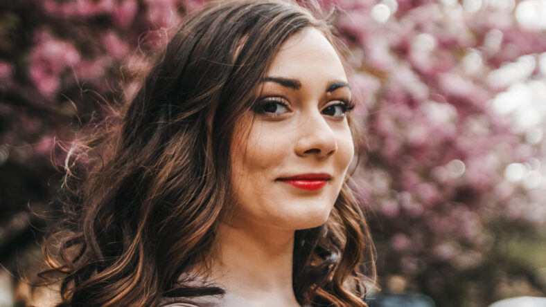 Close up portait of a happy female with sakura in the background