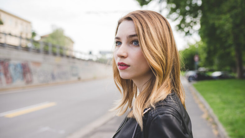 Portrait young blonde woman posing outdoor confident