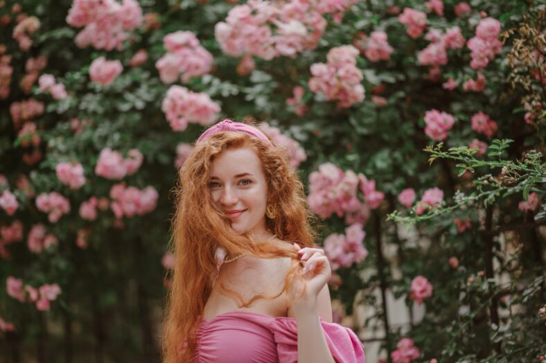 Happy smiling redhead freckled woman plays with