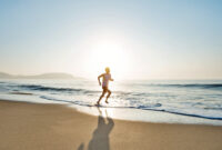 Young man running along beach in the