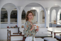 Young woman in bar drinking cocktail