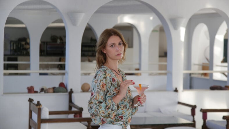 Young woman in bar drinking cocktail