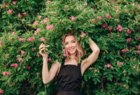 pretty woman standing in front of flowers