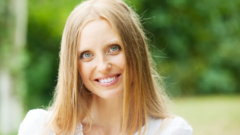 Smiling ordinary middle-aged woman against nature background