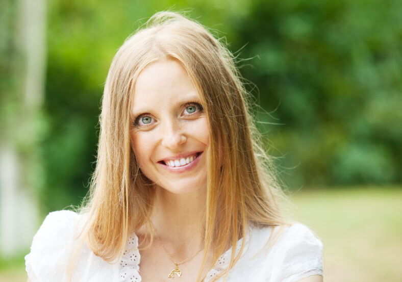 Smiling ordinary middle-aged woman against nature background