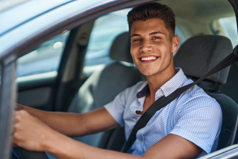 Young hispanic man smiling confident driving car