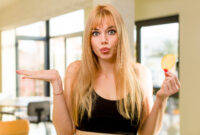 young pretty woman holding a fry unhealthy