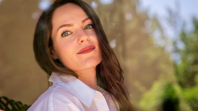 Headshot of beautiful young woman standing behind