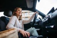 Happy woman driving her new electric car