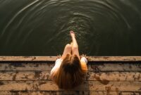 Woman relaxes by the lake sitting on