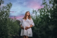 Pregnant woman in white boho summer dress