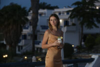 Fashionable young woman holding pina colada cocktail