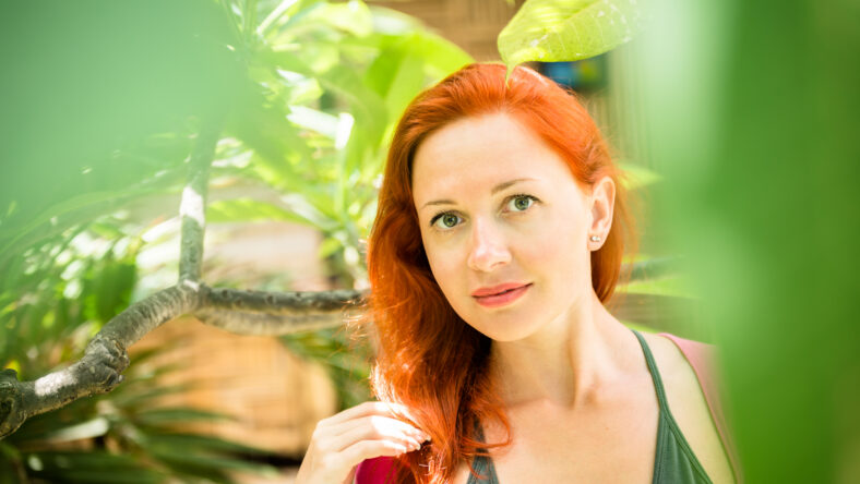 Beautiful red girl in lush tropical forest