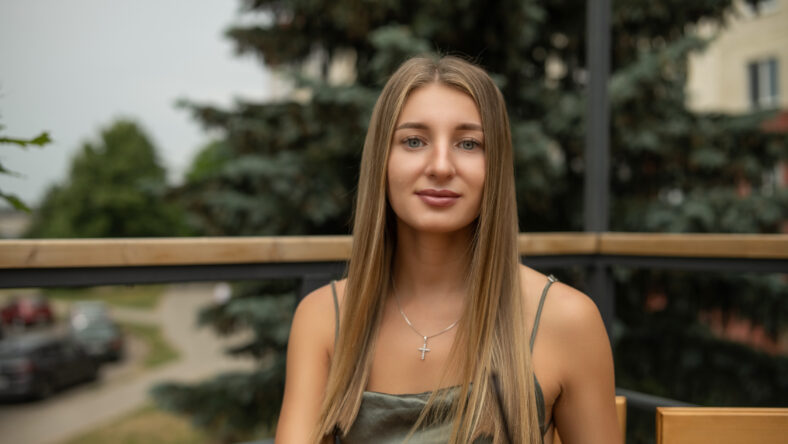 Portrait of a young beautiful blonde girl in a city summer park.