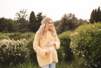 Pregnant woman wearing knitted sweater over nature