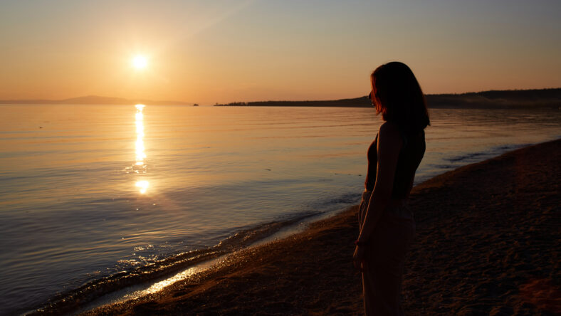 A pretty girl enjoys the sunset on